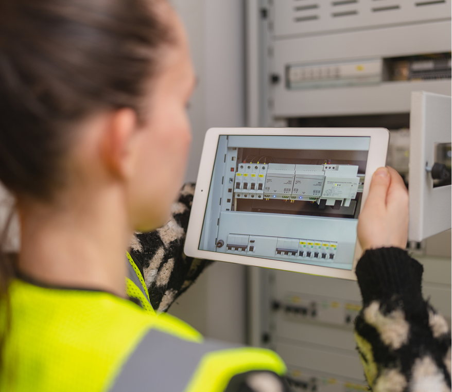 Worker examining circuit board via digital device