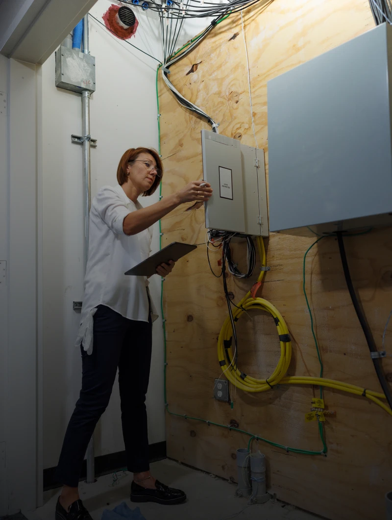 Woman inspecting electrical panel